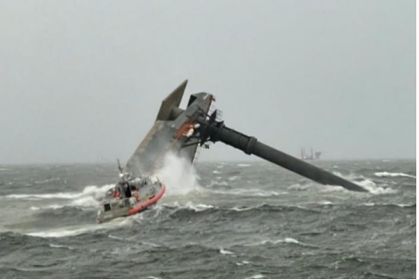 Seacor Power hours after capsizing on its starboard side on the evening of April 13, 2021, with a U.S. Coast Guard response boat