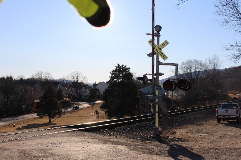Southbound view of highway–rail grade crossing showing active warning devices