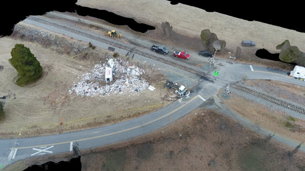 Aerial view of the highway-railroad grade crossing, truck chassis, body, and debris at final rest.