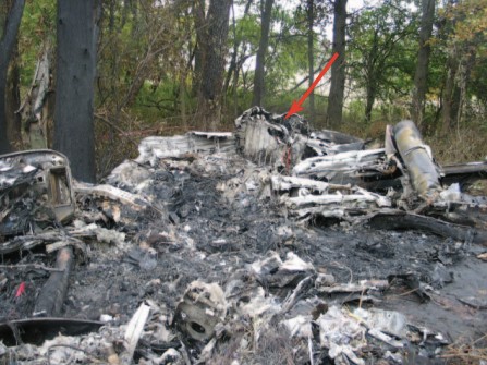  Photograph of the main wreckage area.  The forward section of the airplane is in the foreground, and the tail section is in the
