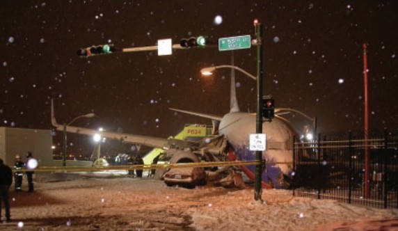  Photograph of the accident airplane in the roadway intersection. (Looking southeast,  towards the departure end of runway 31C.)
