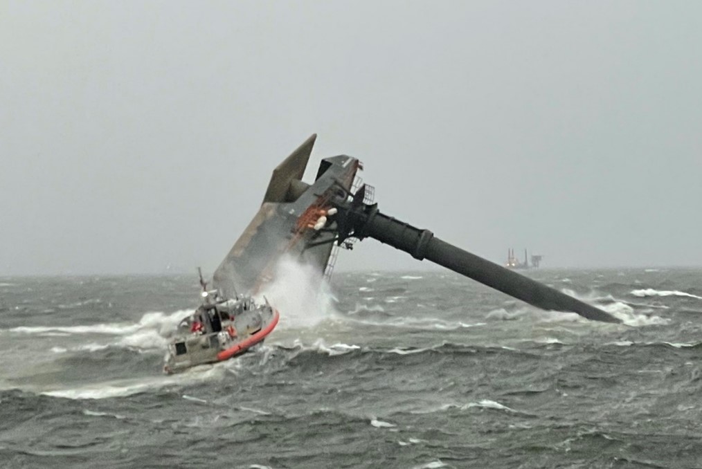 Capsized Seacor Power on the evening of the accident, with a Coast Guard response boat in the foreground.