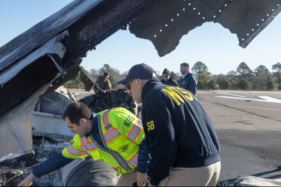 NTSB Member Michael Graham and NTSB staff perform an initial walk around of the wreckage of the Cessna Citation C550 that crashe