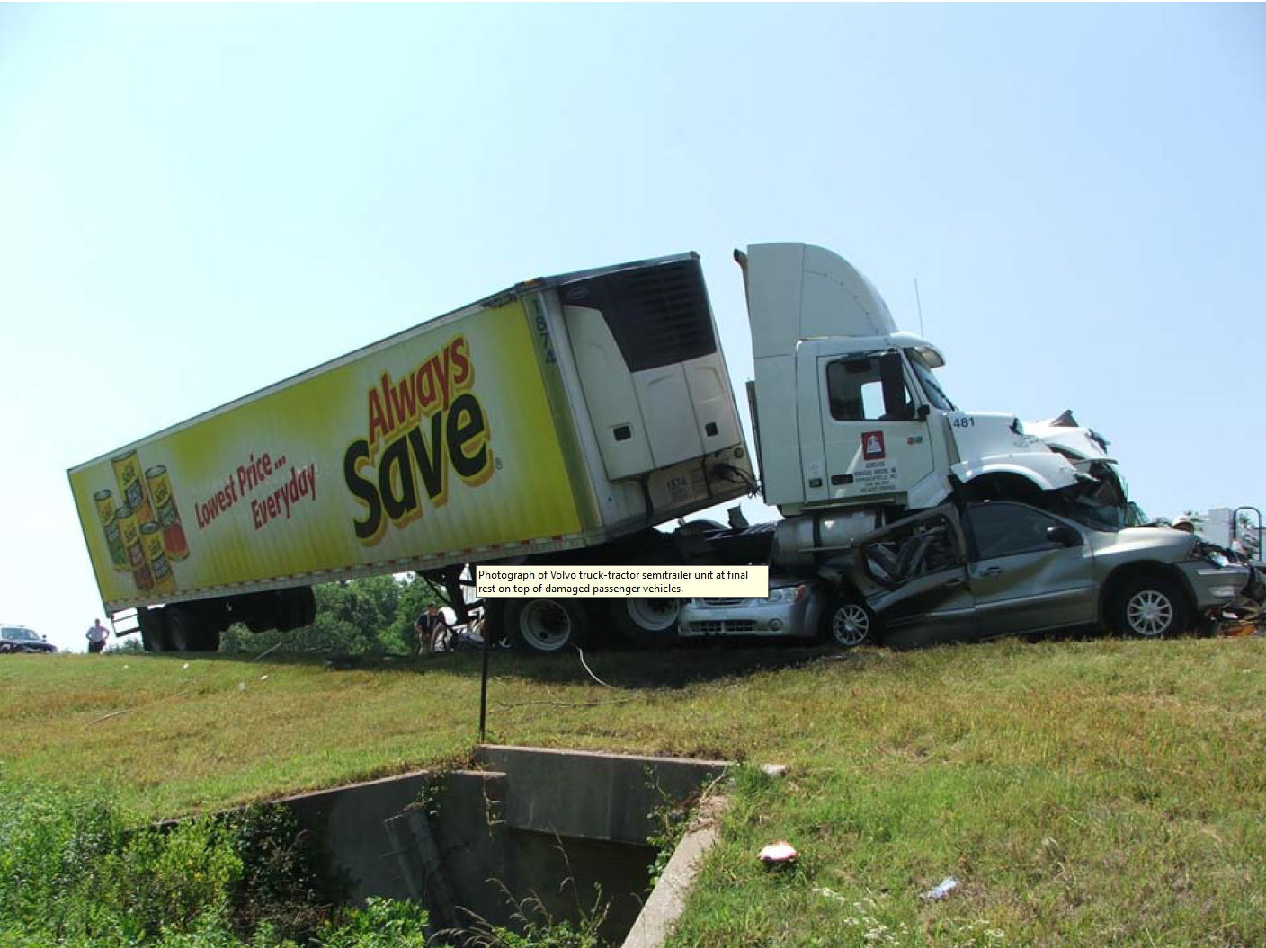 Postaccident photograph showing Volvo truck-tractor semitrailer override of passenger vehicles.
