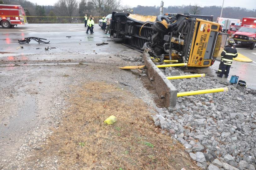 Bus #57 at final rest on its right side and the overturned barricade.