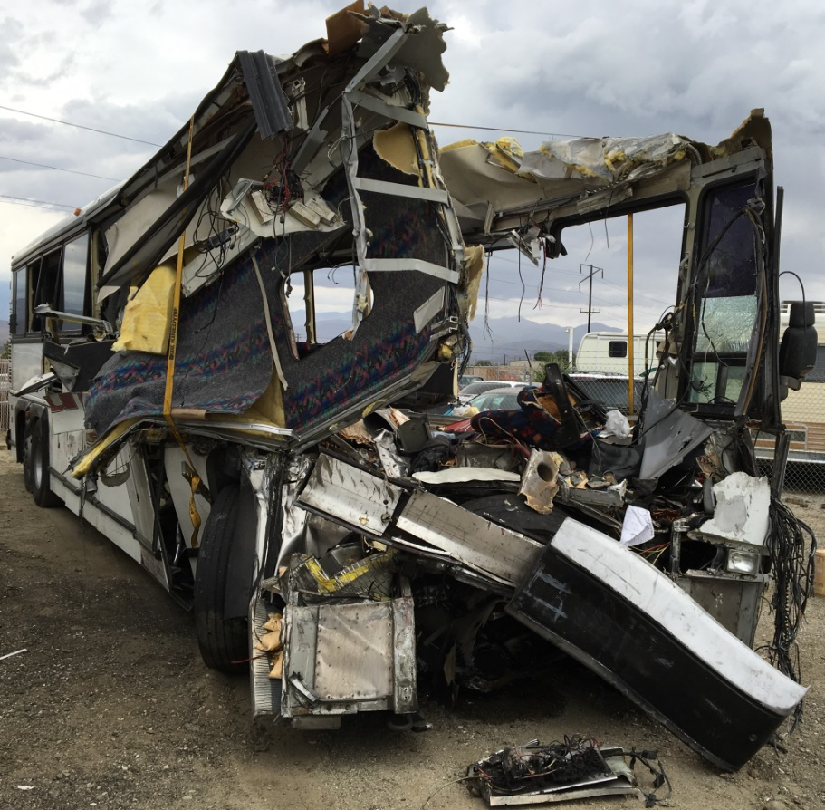 Photo of bus postcrash, showing extensive damage to the front of the vehicle.