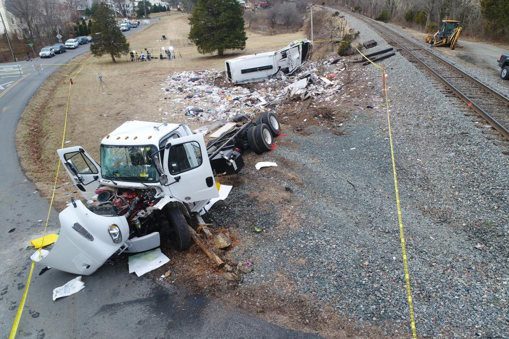 Photo of truck at rest position postcrash, with partial view of displaced hopper.