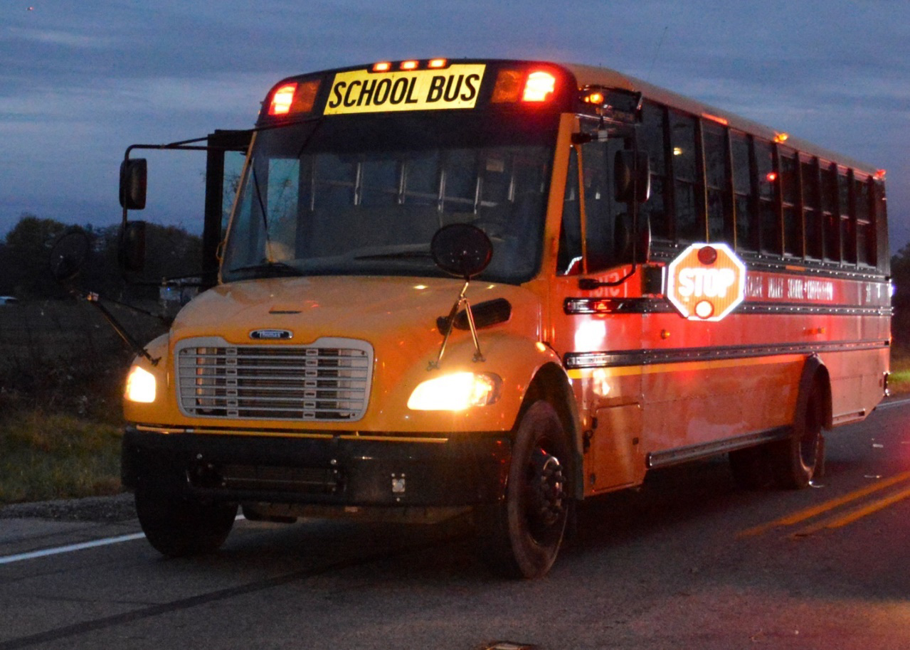 Photo of On-scene postcrash view of school bus with lights in operation.