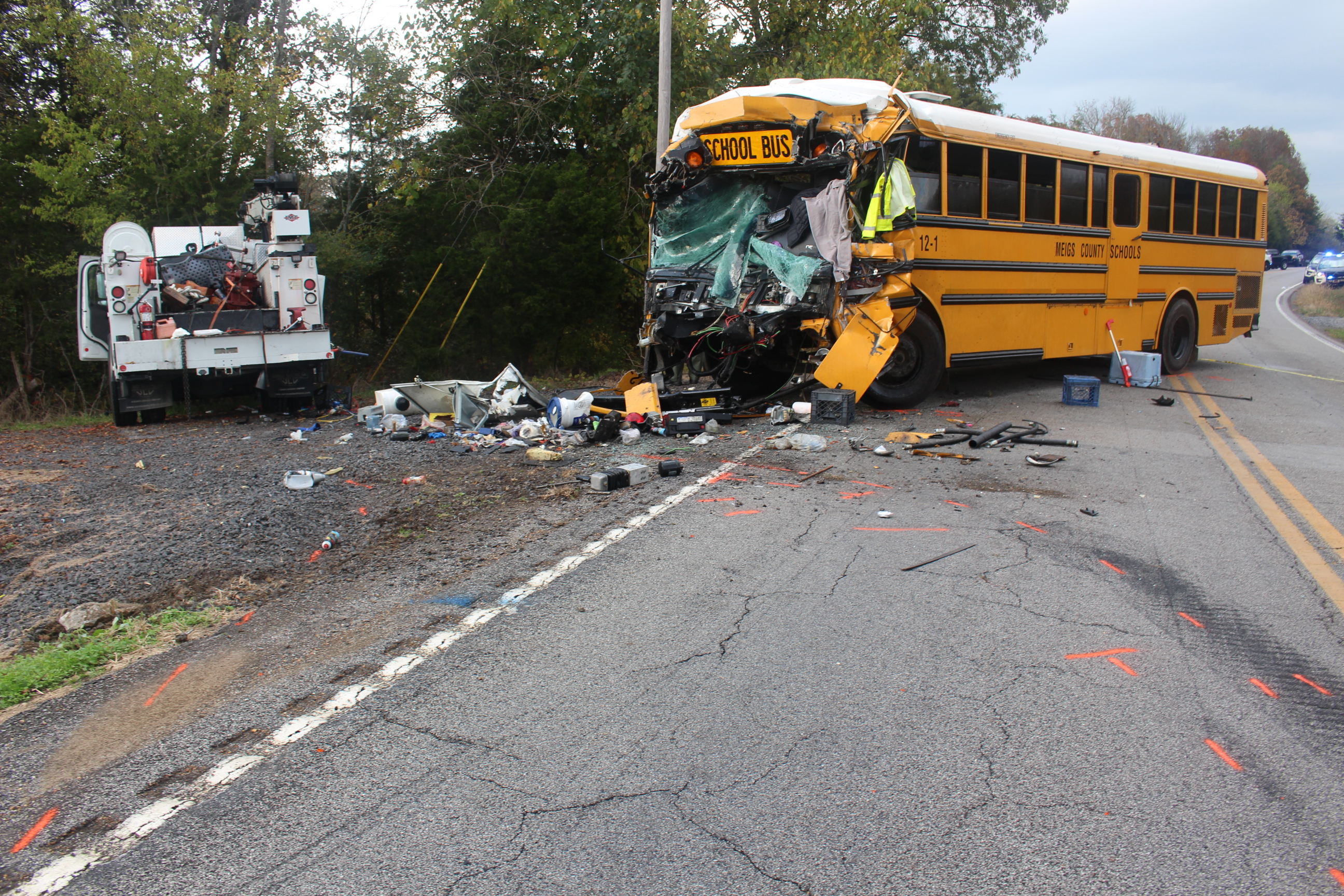 Photo of two vehicles postcrash. The yellow school bus is seen from the front left side and has a severely crushed front. The bu