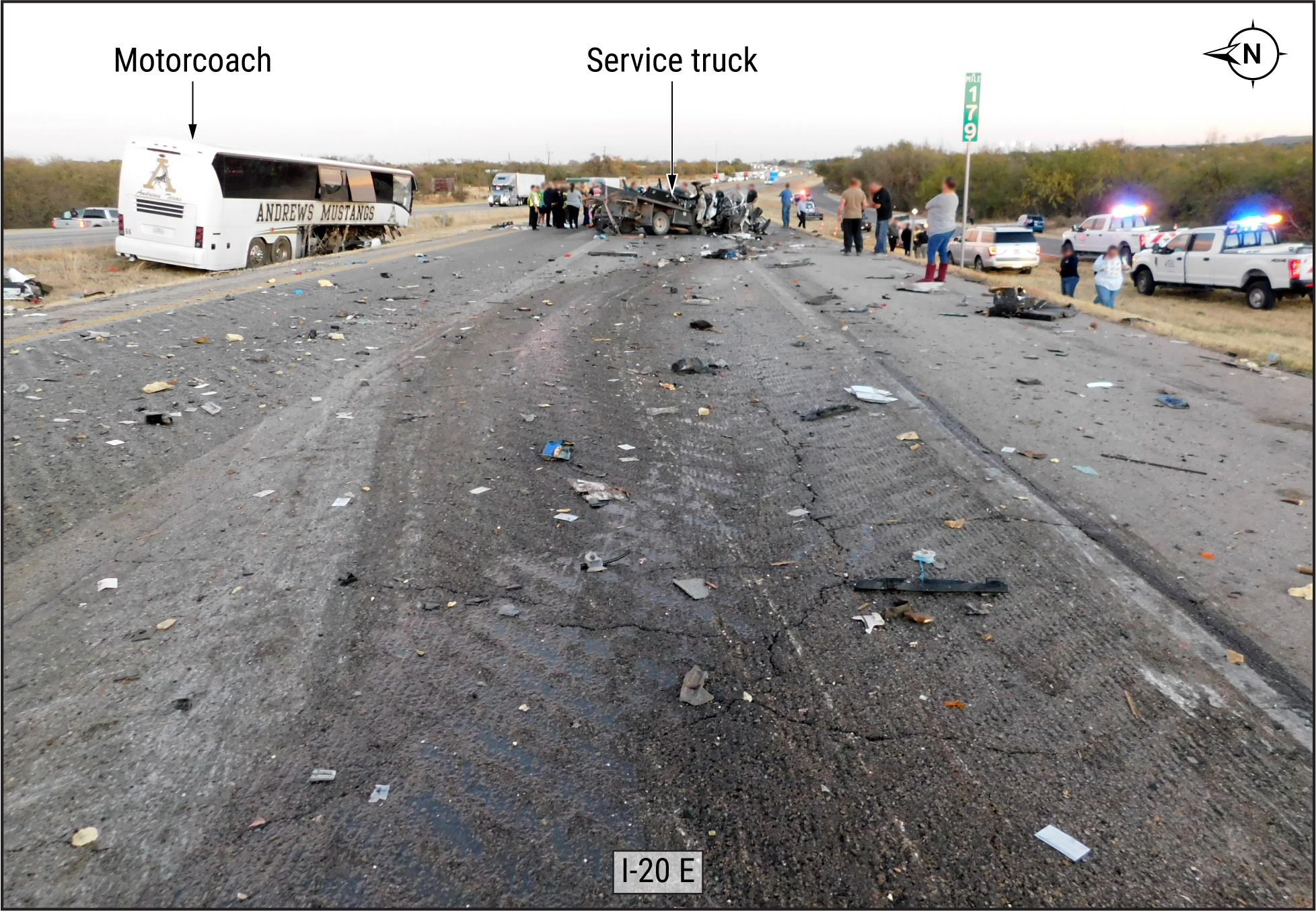 Impact area, with motorcoach in median and service truck in right-hand eastbound traffic lane, both at final rest. (Source: Texa
