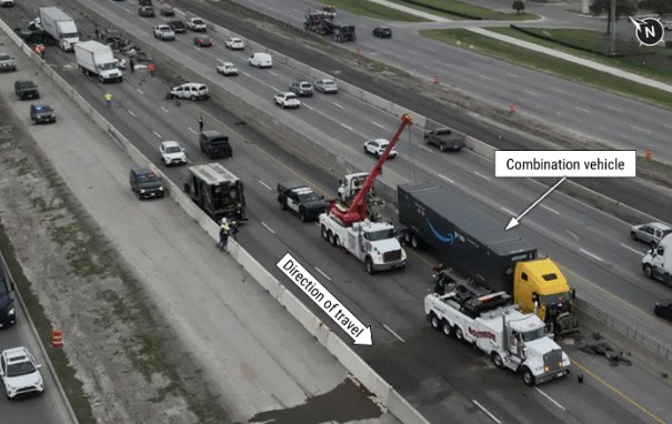 Aerial view of the crash site on I-35 showing the combination vehicle at final rest position. Other crash-involved vehicles can 
