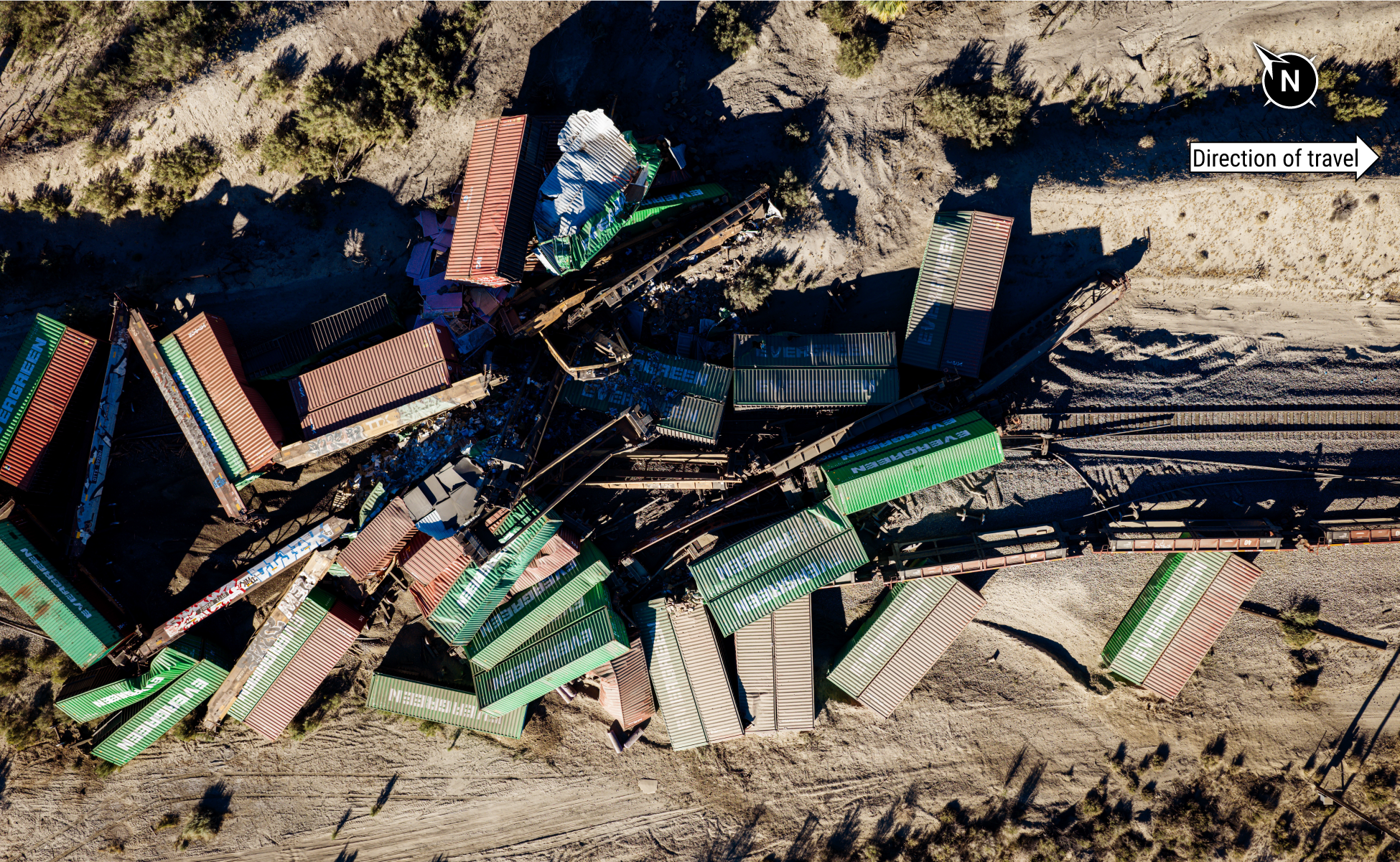 Overhead footage of the accident scene. Railcars are lying on their sides in the desert