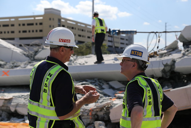 Photo of Investigator-in-Charge Robert Accetta (left) briefs NTSB Chairman Robert Sumwalt on the status of the investigation.