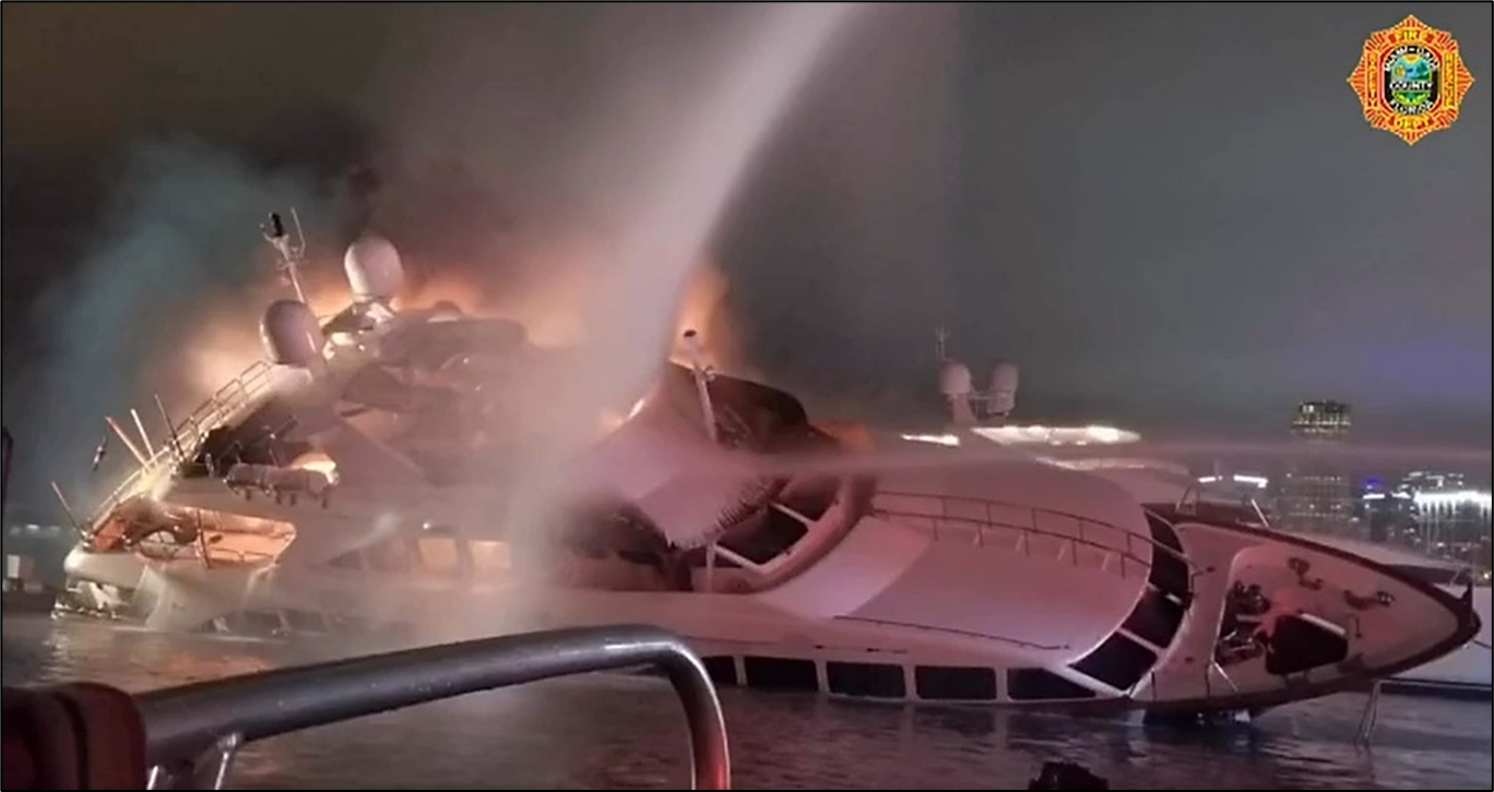 Photo of the yacht Andiamo is seen ablaze and listing to starboard as fireboats attempt to extinguish the fire. 