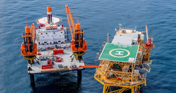 Preaccident photo of the Seacor Power, left, in the lifted configuration alongside an offshore platform.