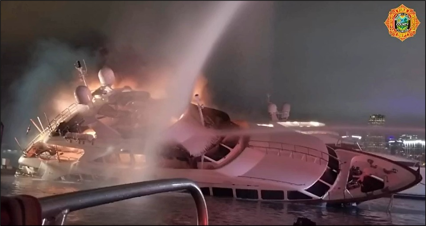 Photo of the yacht Andiamo is seen ablaze and listing to starboard as fireboats attempt to extinguish the fire.